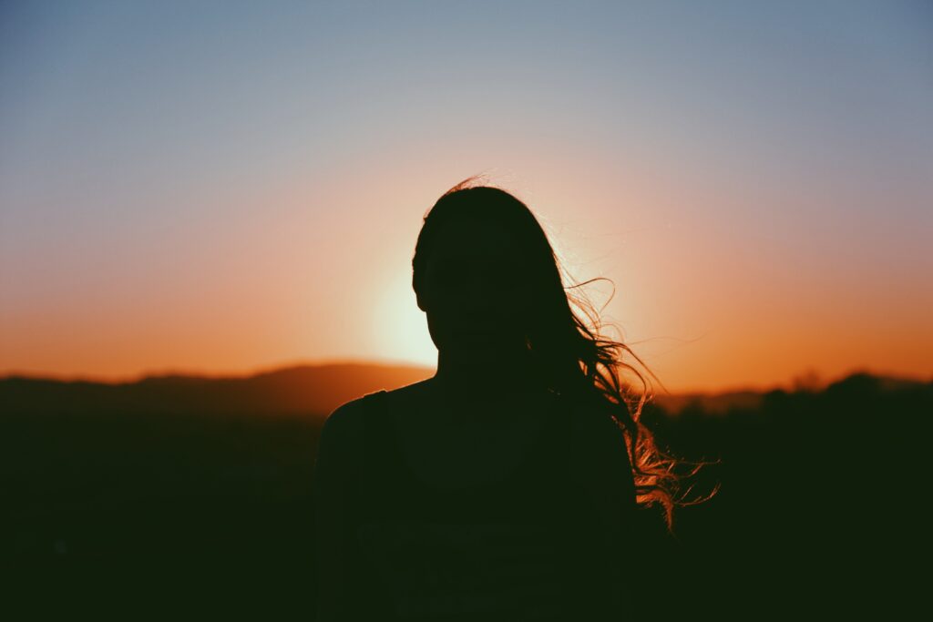 Silhouette einer Frau mit langen Haaren, Sonnenuntergang